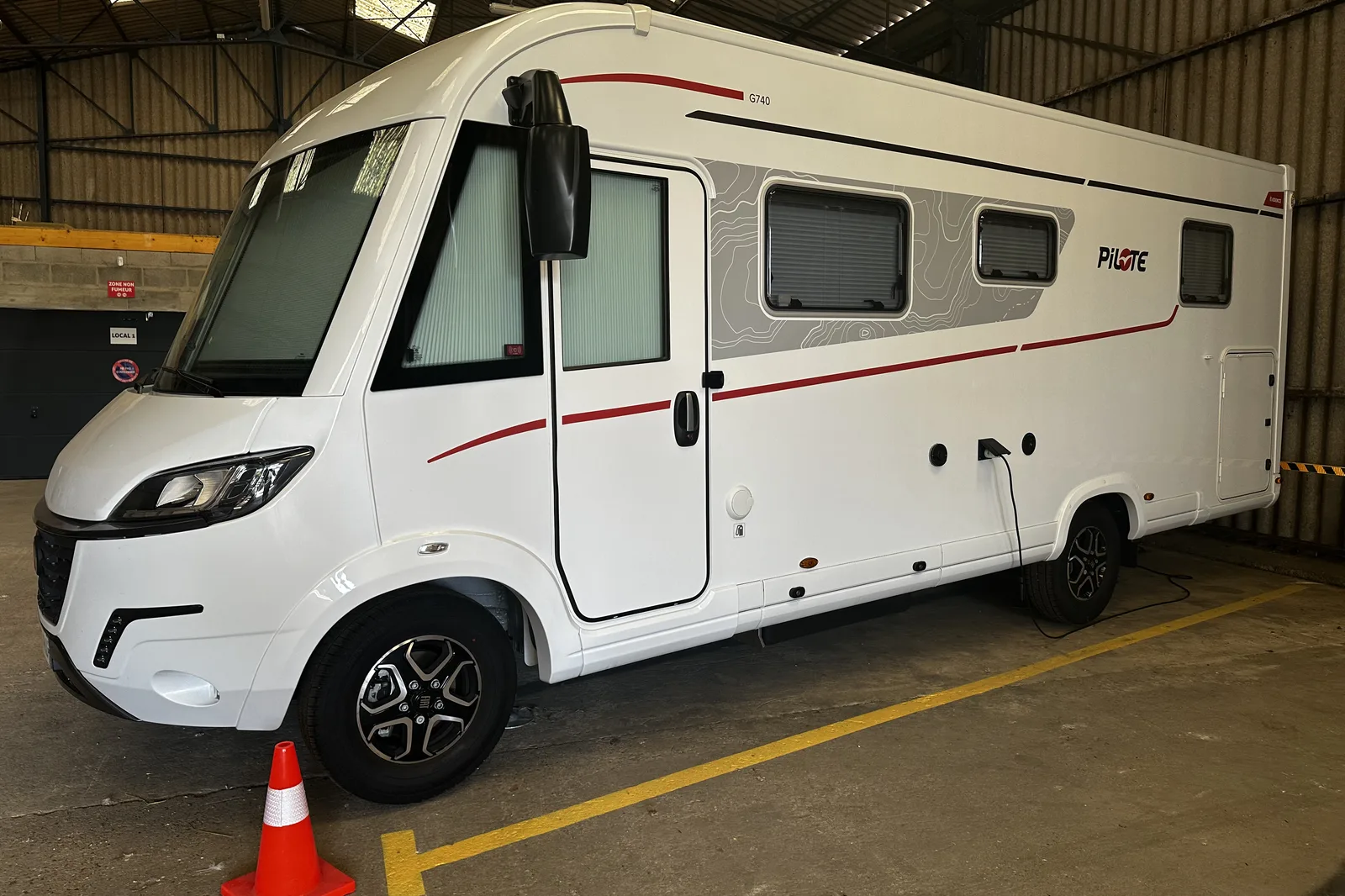 Camping-car stationné dans le local de Sarthe Hivernage, branché sur la prise de son emplacement